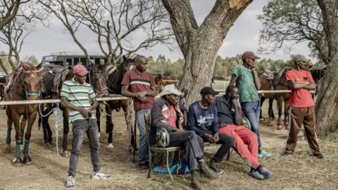 Luis Tato/AFP Stablemen and polo grooms spectate a match during the Casino Cup at the Nairobi Polo Club in Nairobi , Kenya - Saturday 23 September 2023