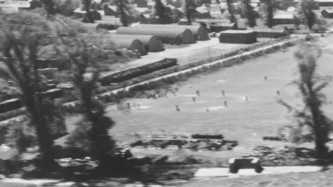 Historic England Archive/USAAF P Detail of an oblique aerial photograph taken on an F-5 of the 31st PR Squadron, showing a game of baseball being played on a US Army camp on the outskirts of Devizes, Wiltshire, 30 April 1944.