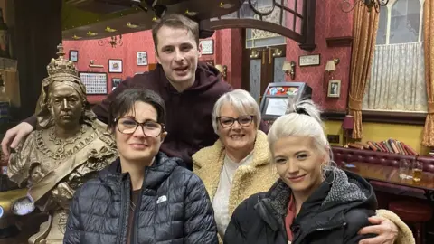 Brain Tumour Research Kylie Weatherby, her mum Barbara and Danielle with Max Bowden who plays Ben Mitchell inside the Queen Vic