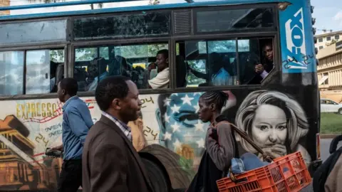 Getty Images A privately owned minibus with a mural of the American television drama, 24, passes a bus stop in Nairobi, Kenya - Tuesday 4 December 2018