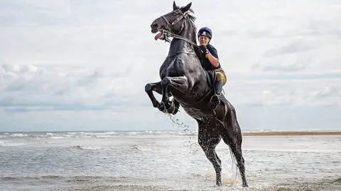 Household Cavalry trooper and horse on Holkham beach