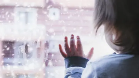 Xesai / Getty Images Child at a window