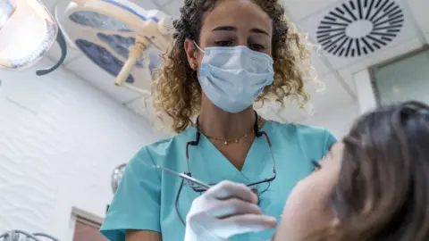 Getty Images dentist-treating-young-girl.