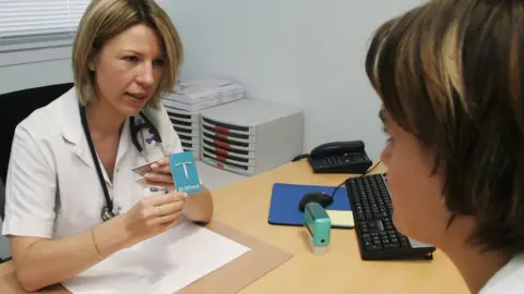 Getty Images doctor showing patient a mirena coil- birth control