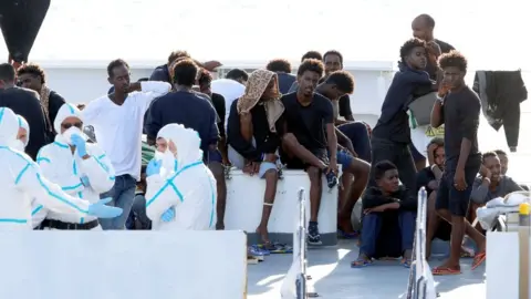 Reuters Migrants wait to disembark from the Italian coast guard vessel Diciotti at the port of Catania, Italy, August 22, 2018