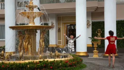 Warner Brothers Movie still from Crazy Rich Asians showing Awkwafina and Constance Wu running towards each other