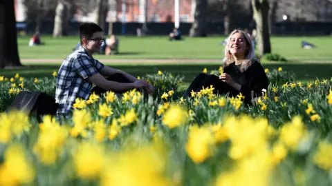 EPA Two people sit among the daffodils in St. James's Park in London on Tuesday