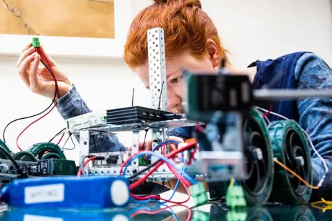 Douglas Fry Woman working on a robot