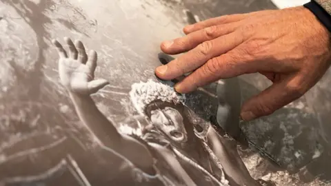 A man touches a 3D printed photograph
