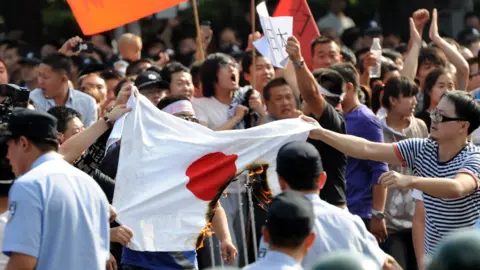 AFP Chinese protesters burn a Japanese national flag during an anti-Japanese protest over the Diaoyu islands issue, known as the Senkaku islands in Japanese, outside the Japanese Embassy in Beijing on September 15, 2012