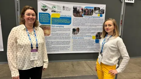 Royal Agricultural University Prof Cannon and Prof Melnyk in front of a display board, one on either side