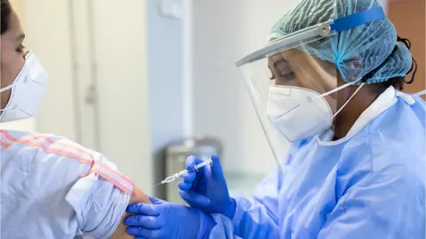 Getty Images Woman receiving a vaccine