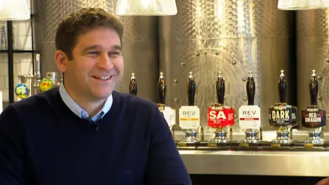 BBC Jon Bridge sat in front of a bar