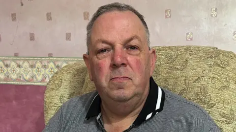 BBC Gordon Harries sat on his sofa