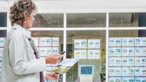 Getty Images Woman looking a house details