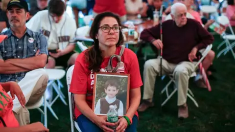 Getty Images A 2018 image of Francine Wheeler holding a photograph of her son Ben