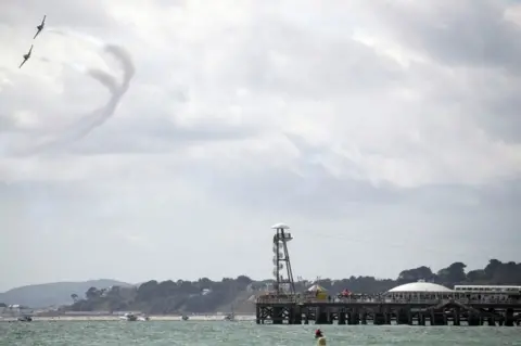 PA Media The Strikemaster pair perform for the crowds on day one of the Bournemouth Air Festival