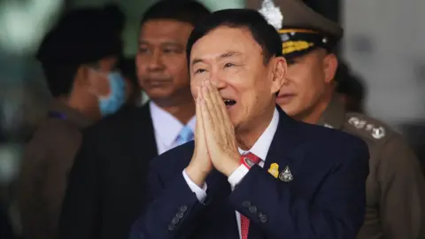 Former Thai prime minister Thaksin Shinawatra greets supporters as he arrives at Don Mueang International Airport on August 22, 2023 in Bangkok, Thailand.