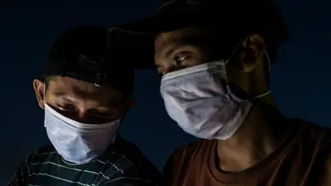 Getty Images Two men wearing masks in Aceh