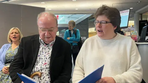 Alex Dunlop/BBC Neil Croft sitting next to his wife in the choir