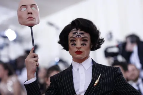 Reuters Ezra Miller holds up a mask