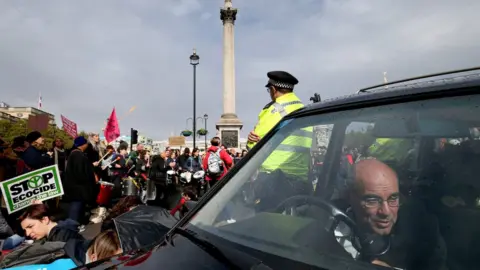 PA Media The driver of a hearse attached to the wheel with a bicycle lock