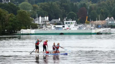 Reuters Family paddle boarding during summer in Windermere