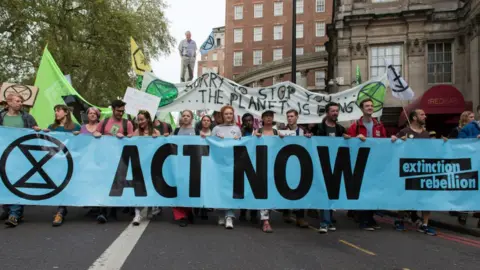 Getty Images Extinction Rebellion holding a banner saying "Act Now"