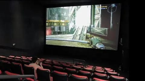 CGV A young man playing computer games in a CGV cinema in South Korea