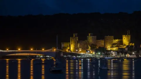 Cadw Conwy Castlew lit up in yellow