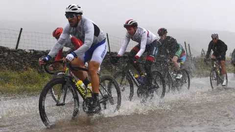 Getty Images Cyclists ride through flooded race route on Cray Summit