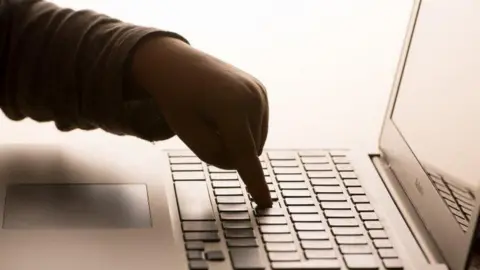 Child's hand on computer