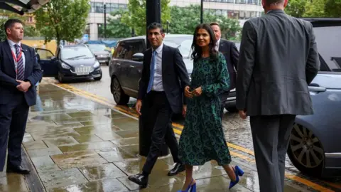 Reuters Rishi Sunak and his wife Akshata Murty step out of a car in Manchester on Sunday