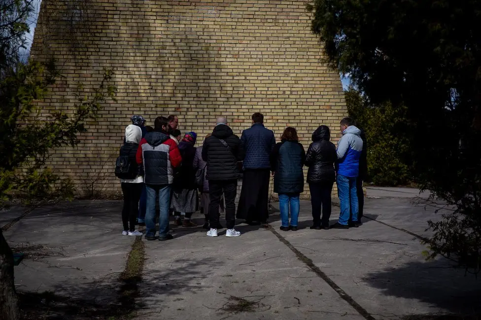 BBC The family gathers for a small funeral service for Vitaliy