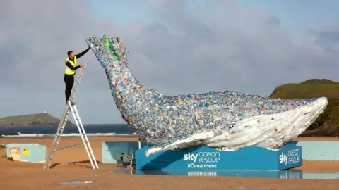 PA Jordan Asil puts the finishing touches to a 10-metre long whale unveiled by Sky Ocean Rescue at Newquay, Cornwall,