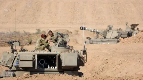 EPA-EFE/REX/Shutterstock sraeli soldiers with armoured fighting vehicles at an area along the border with Gaza