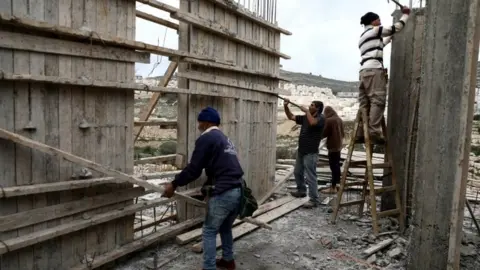 Reuters File photo showing Palestinians working at a building site at the Israeli settlement of Ramat Givat Zeev on 19 March 2020