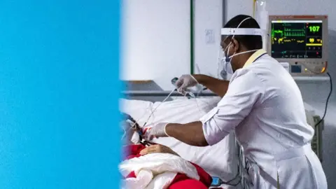 Getty Images A nurse cares for a Covid-19 patient at a hospital in Rio de Janeiro state, May 2020