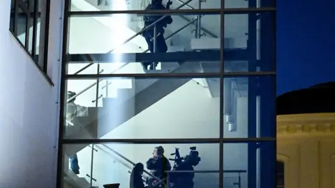 AFP Police officers search school