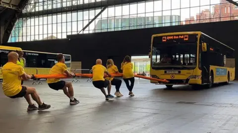 People pulling bus