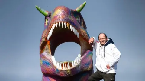 Jake Westlake, with the dinosaur head which he painted