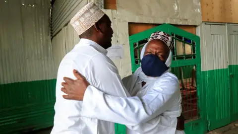 Reuters Muslim faithful embrace before performing the Eid al-Fitr prayers, marking the end of the holy fasting month of Ramadan, outside a mosque closed amid concerns about the spread of the coronavirus disease (COVID-19), in Nairobi, Kenya, May 24, 2020.