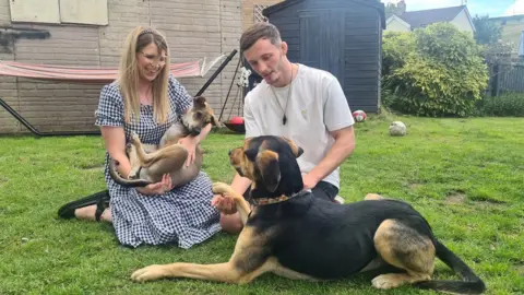 Carys Hawkey and Cameron Clarke with Rodney in Carys' arms and their other dog Khabib