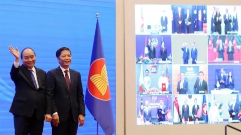 EPA Vietnam"s Prime Minister Nguyen Xuan Phuc (L) and Minister of Industry and Trade Tran Tuan Anh (R) cheer after the virtual signing ceremony for the Regional Comprehensive Economic Partnership (RCEP) in Hanoi, Vietnam, 15 November 2020.