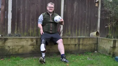 Andrew Woodger/BBC Sam Nunn sitting on a garden wall