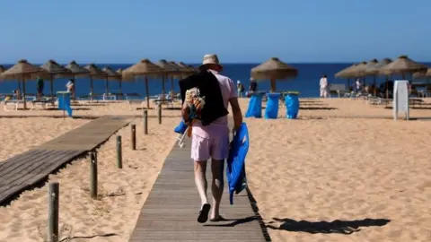 Reuters A man arrives at Vilamoura beach amid the coronavirus disease (COVID-19) pandemic, in Quarteira