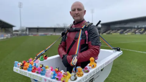 BBC Man dressed as Deadpool carrying a bathtub