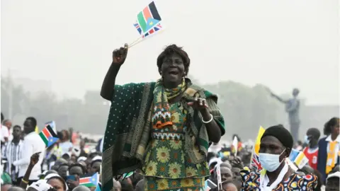 AFP Woman holding South Sudan flag cheering amongst a crowd