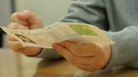 Jin-yeong holds her attendance card