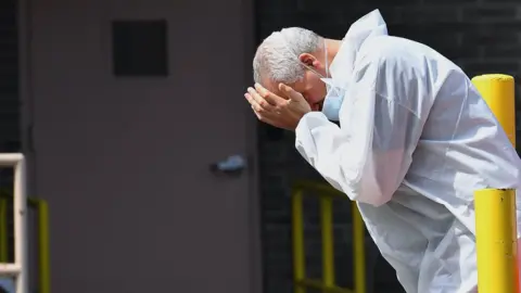 AFP A medical personnel rubs his face outside the Wyckoff Heights Medical Center on April 07, 2020